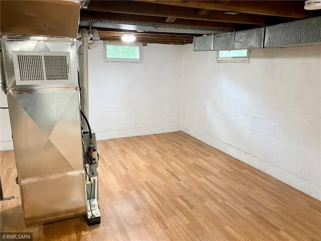 basement featuring heating unit and wood finished floors