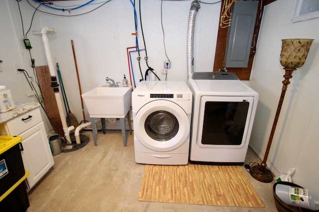 laundry area featuring electric panel, light wood-style floors, laundry area, washer and dryer, and a sink