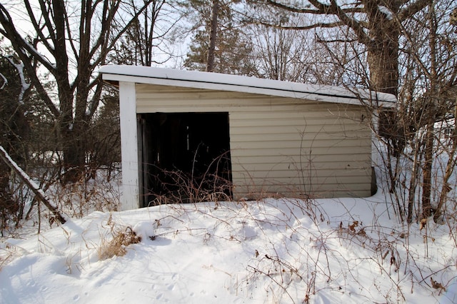 snow covered structure featuring an outbuilding