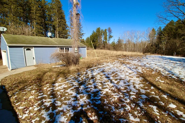 yard layered in snow with an outbuilding