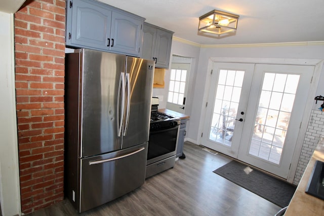 kitchen with ornamental molding, dark wood-style flooring, light countertops, stainless steel appliances, and french doors