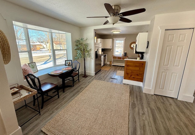 living area with a textured ceiling, dark hardwood / wood-style floors, and ceiling fan