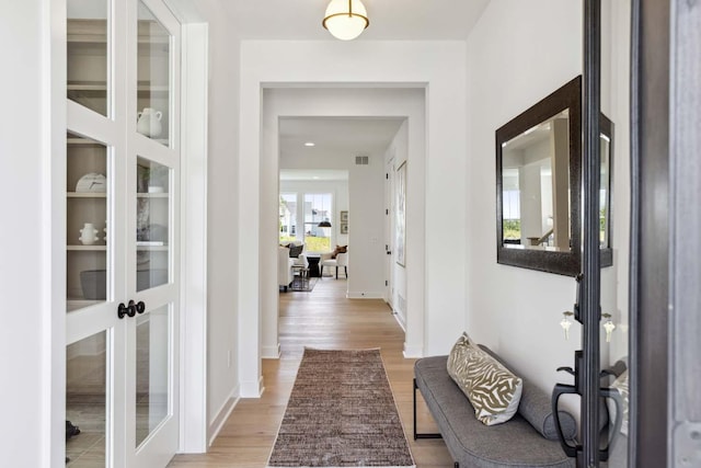 corridor with french doors and light wood-type flooring