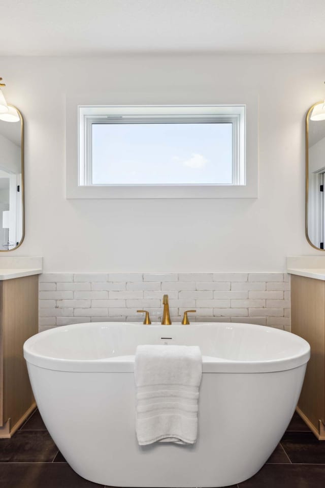 bathroom featuring vanity, a bath, tile walls, and a wealth of natural light