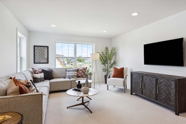 living room featuring light colored carpet and a textured ceiling