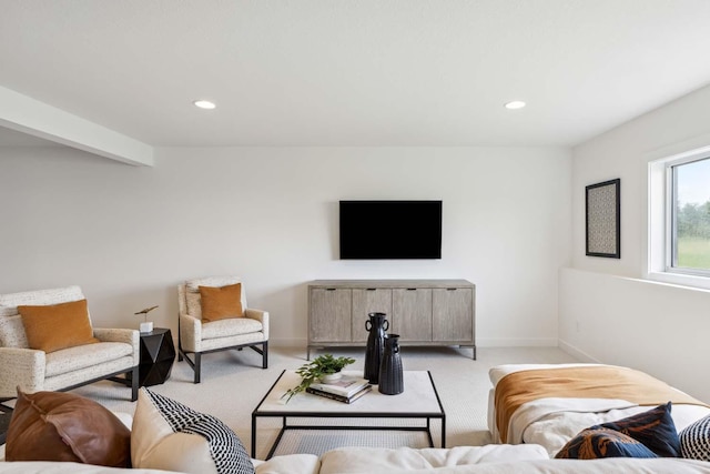 carpeted living room featuring beamed ceiling