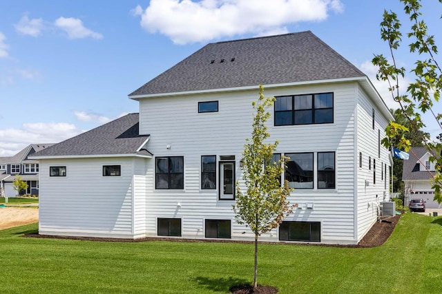 rear view of property featuring a yard and cooling unit