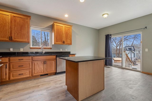 kitchen with sink, light hardwood / wood-style flooring, a kitchen island, and dishwasher