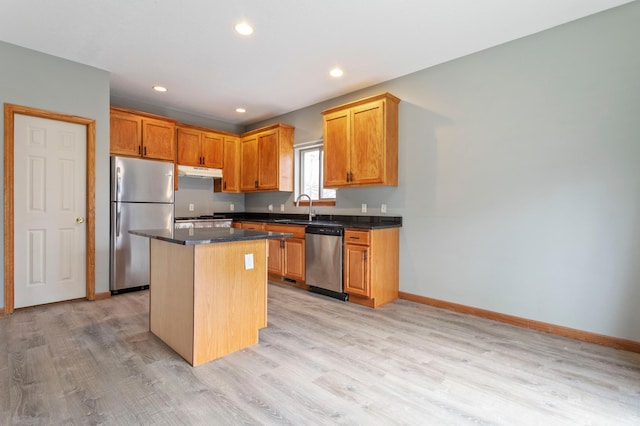 kitchen featuring sink, a kitchen island, stainless steel appliances, and light wood-type flooring