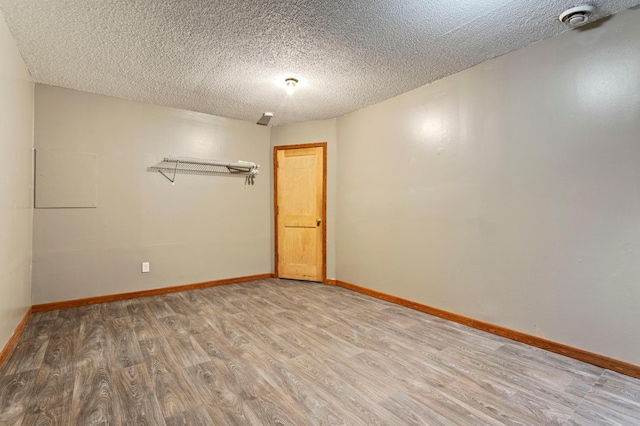 spare room with hardwood / wood-style floors and a textured ceiling