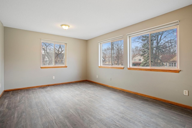 spare room featuring hardwood / wood-style floors and a healthy amount of sunlight