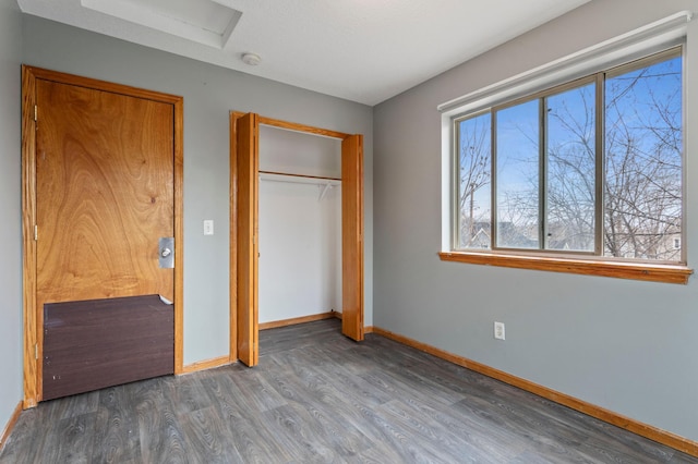 unfurnished bedroom with a closet and dark hardwood / wood-style floors