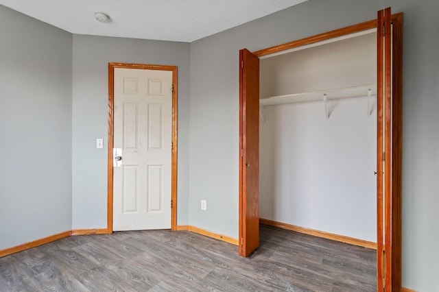 unfurnished bedroom with hardwood / wood-style floors and a closet