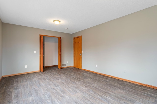 unfurnished room featuring light wood-type flooring and a textured ceiling