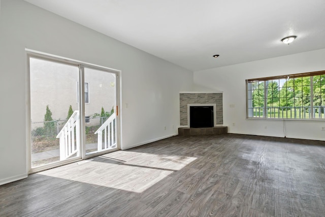 unfurnished living room with a tile fireplace and wood-type flooring