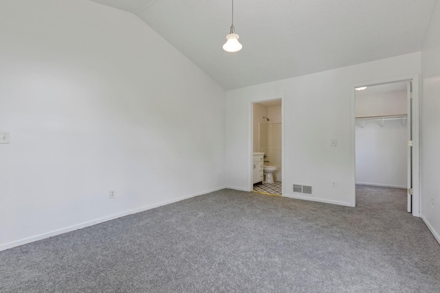 unfurnished bedroom featuring vaulted ceiling, a closet, carpet flooring, a spacious closet, and ensuite bathroom