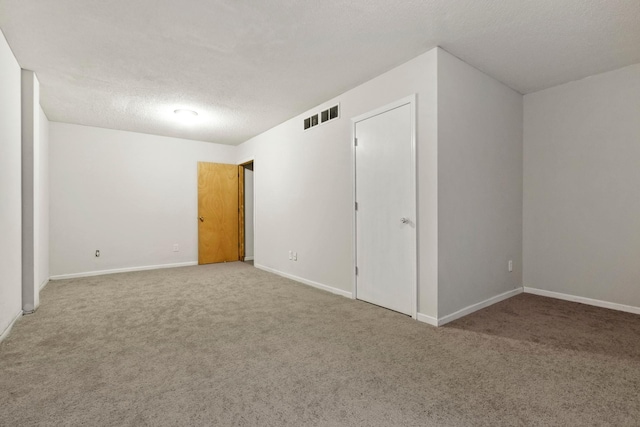 spare room featuring carpet floors and a textured ceiling