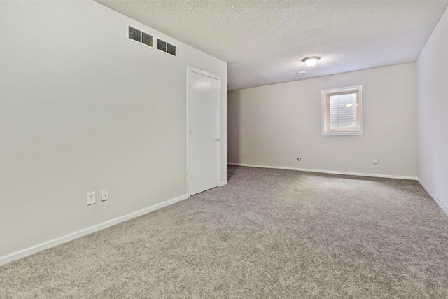 empty room with carpet flooring and a textured ceiling