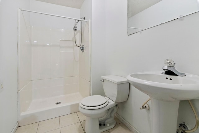 bathroom with a shower, sink, tile patterned flooring, and toilet