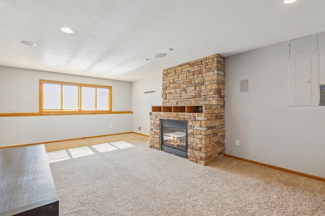 unfurnished living room featuring electric panel, a textured ceiling, carpet, a fireplace, and baseboards