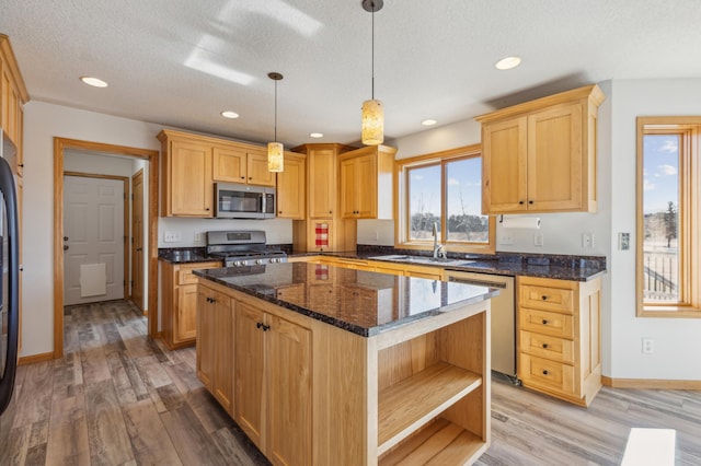 kitchen with a sink, a kitchen island, light wood-type flooring, stainless steel appliances, and open shelves