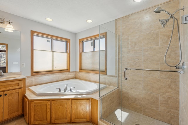 full bath with vanity, a shower stall, plenty of natural light, and a garden tub