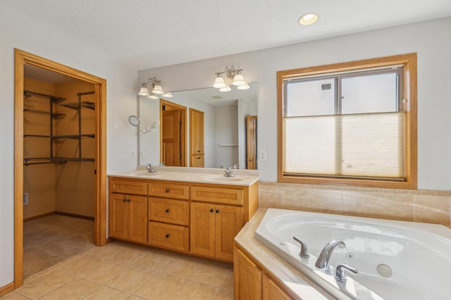 full bath with a walk in closet, a sink, tile patterned flooring, double vanity, and a whirlpool tub