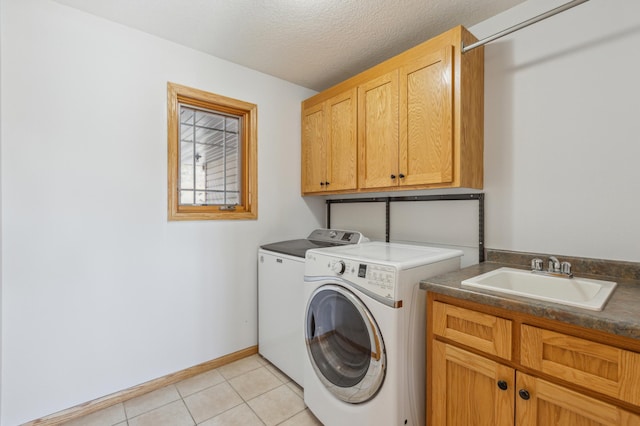 laundry area featuring independent washer and dryer, a sink, a textured ceiling, cabinet space, and light tile patterned flooring