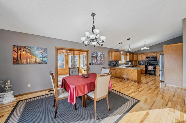 dining space with vaulted ceiling, baseboards, a notable chandelier, and light wood finished floors