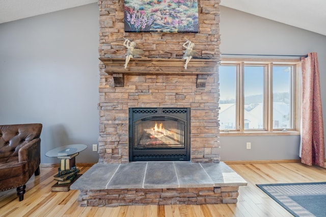 interior space featuring a stone fireplace, wood finished floors, and baseboards