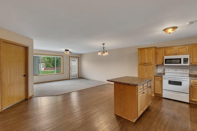 615 Cottonwood Ave, Litchfield, MN 55355 - kitchen featuring white appliances, a center island, open floor plan, a chandelier, and dark countertops