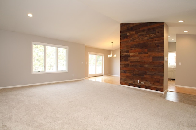 unfurnished room with baseboards, vaulted ceiling, a chandelier, recessed lighting, and light colored carpet