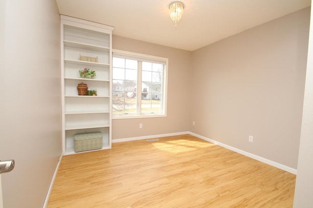 unfurnished room with light wood-style flooring, baseboards, and visible vents