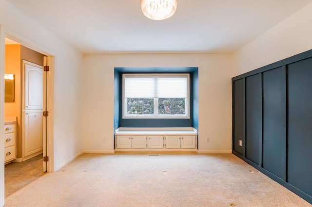 unfurnished bedroom featuring light carpet, visible vents, and baseboards