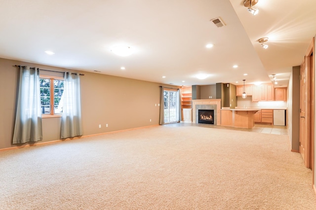 unfurnished living room featuring light carpet, a tile fireplace, visible vents, and recessed lighting