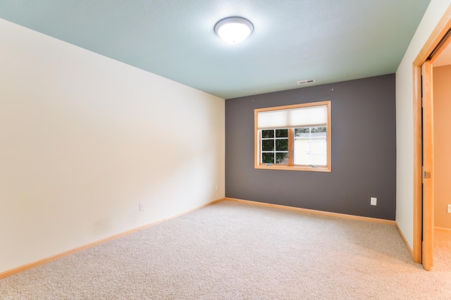 carpeted empty room with baseboards and visible vents