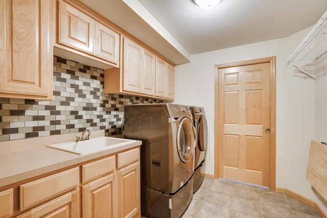 clothes washing area featuring a sink, baseboards, cabinet space, and washer and dryer