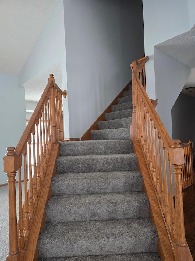 stairway featuring hardwood / wood-style floors and high vaulted ceiling