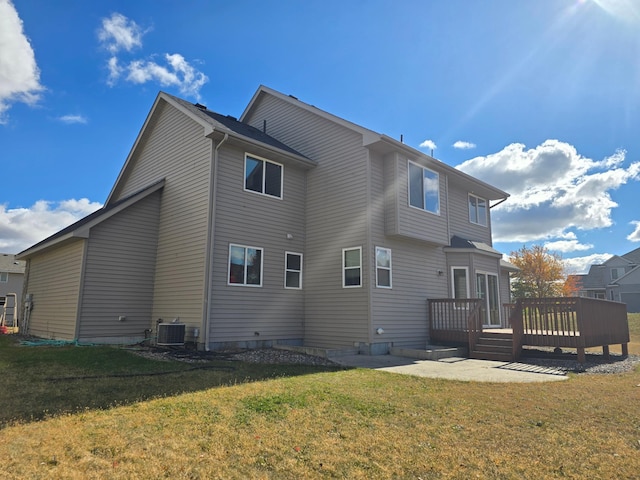 back of house with a wooden deck, a lawn, and central air condition unit