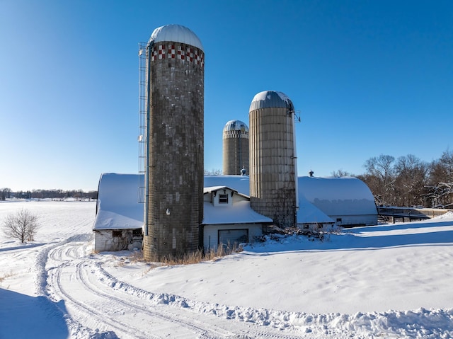 snow covered structure featuring a garage