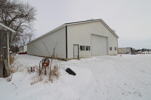 snow covered structure with an outbuilding