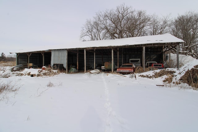 snow covered structure with an outdoor structure and an outbuilding