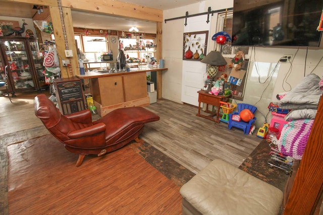 living area with a barn door and wood finished floors