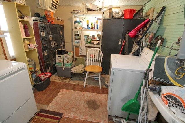 laundry room with wood finished floors, laundry area, and wood walls