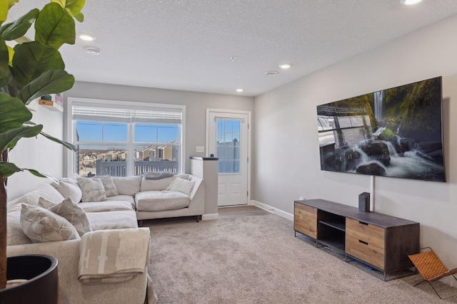 living room with a textured ceiling, recessed lighting, carpet, and baseboards