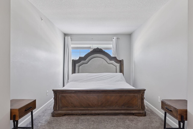 carpeted bedroom featuring a textured ceiling and baseboards