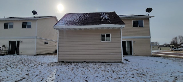 view of snow covered back of property