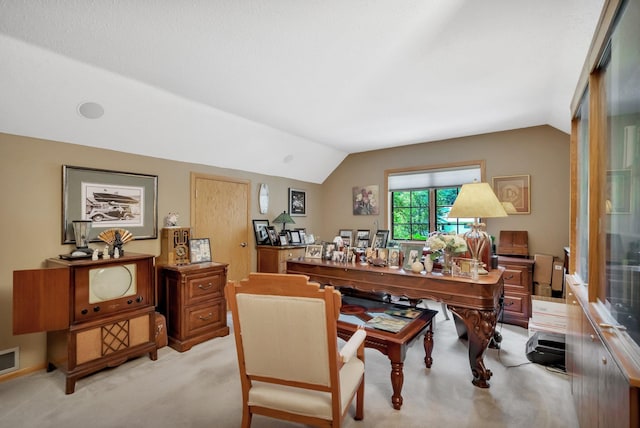 carpeted office space with vaulted ceiling