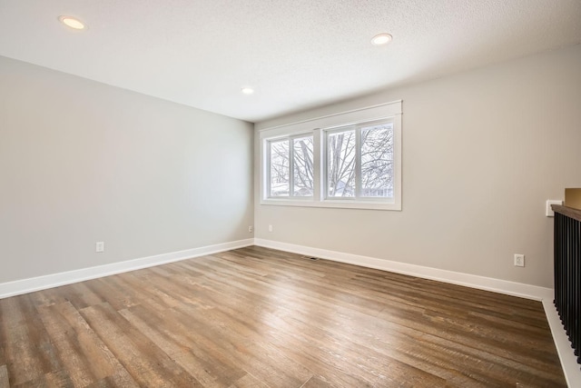 spare room with wood-type flooring and a textured ceiling