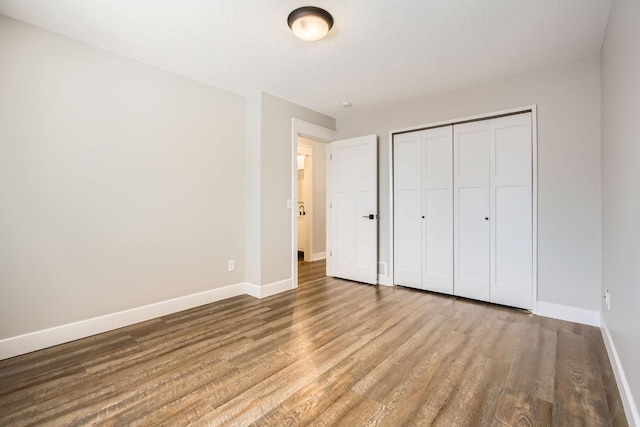 unfurnished bedroom featuring hardwood / wood-style flooring and a closet